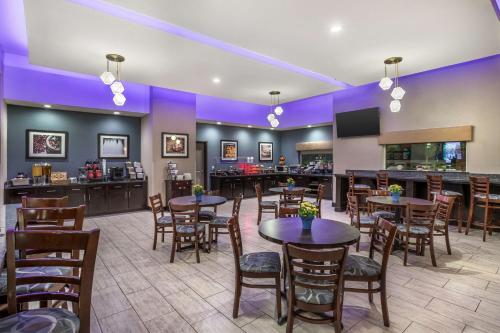 a restaurant with tables and chairs and a bar at Best Western Plus Lake Jackson Inn & Suites in Lake Jackson