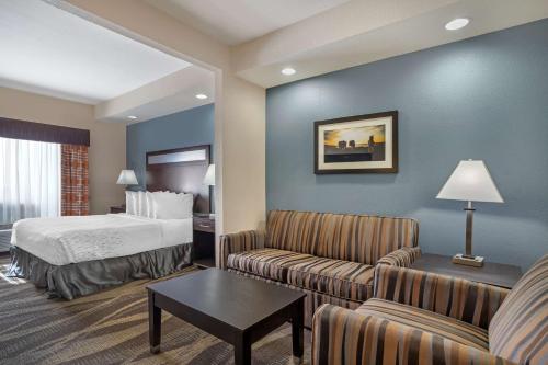 a hotel room with a bed and a living room at Best Western Plus Lake Jackson Inn & Suites in Lake Jackson