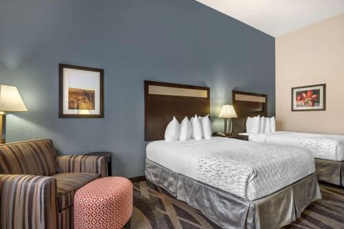 a hotel room with two beds and a chair at Best Western Plus Lake Jackson Inn & Suites in Lake Jackson