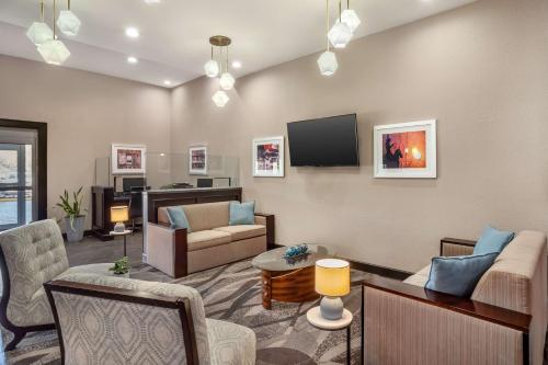 a living room with a couch and a tv at Best Western Plus Lake Jackson Inn & Suites in Lake Jackson