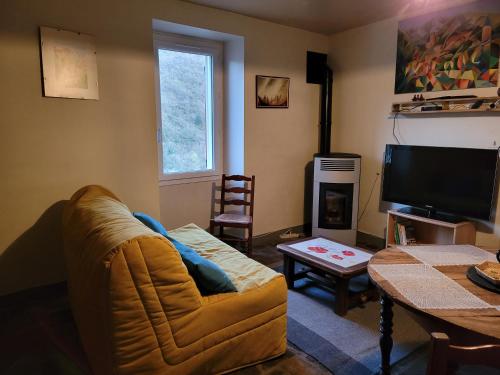 un salon avec un canapé et une télévision dans l'établissement Lou clapas, à Comprégnac