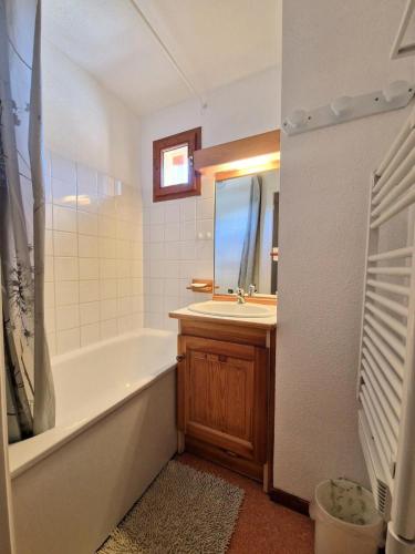 une salle de bain avec une baignoire, un lavabo et un miroir dans l'établissement Les Chalets D'arrondaz - 3 pièces 4/6 personnes avec vue sur la Vanoise MAE-2939, à Modane