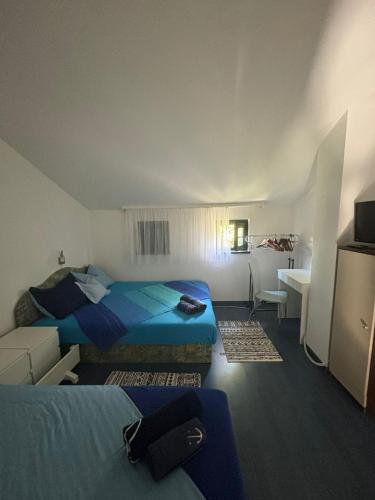 a hotel room with two beds and a desk at Studio apartman Pepi in Stinica