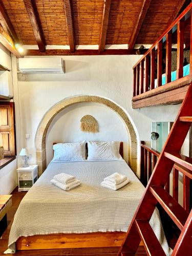 a bedroom with a bed with two towels on it at Ypatia Cozy Castle Suite Apartment with Loft in Monemvasia