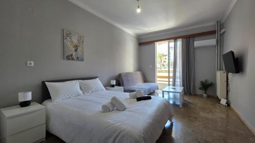 a bedroom with a large white bed and a tv at Cozy Studio 6 in Patra