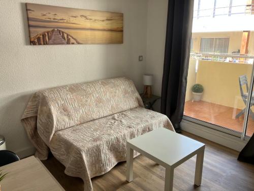 un salon avec un canapé et une table dans l'établissement Superbe studio au bord de la mer à Sete, à Sète