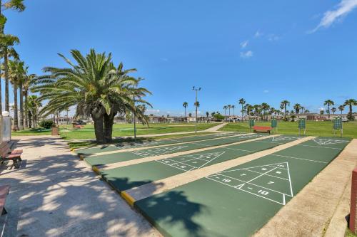 a tennis court in a park with a palm tree at LIV Resort, Private Jacuzzi and Pet Friendly in Port Isabel