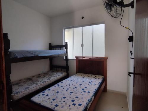 a room with two bunk beds and a window at Casa 1 Vila do Peró in Cabo Frio