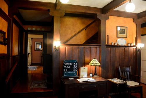 Habitación con paredes de madera y mesa con lámpara. en Stone Soup Inn en Indianápolis