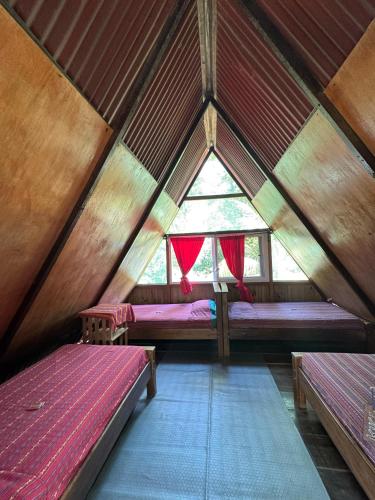 a room with two beds and a window in a tent at El Portal De Champey in Lanquín