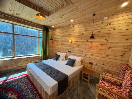 a bedroom with a bed in a room with wooden walls at Apple Land by Naavagat in Jibhi