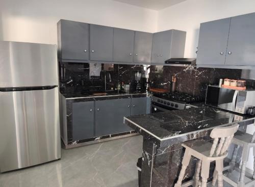 a kitchen with a marble counter and a refrigerator at CaSa NeNa in Los Limones