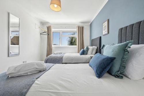 two beds in a bedroom with blue and white at Cotswolds Vista, 3 bed, 2 bathrooms, complimentary parking in Cirencester