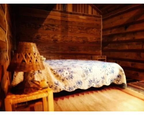 a bedroom with a bed in a log cabin at Chalé Aiuruoca in Aiuruoca