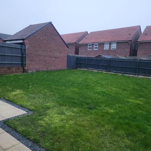 a yard with a fence next to some houses at Luxury Home -Private Rooms- 3 mins from Alexandra Hospital, Redditch in Studley