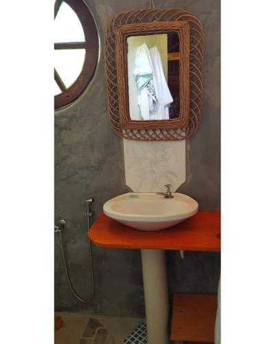a bathroom with a sink and a mirror at Chalé Aiuruoca in Aiuruoca