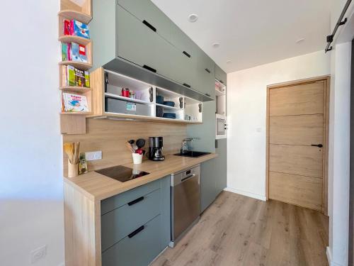 une cuisine avec des placards bleus et un comptoir en bois dans l'établissement Le Spot de Jean, à Talmont-Saint-Hilaire