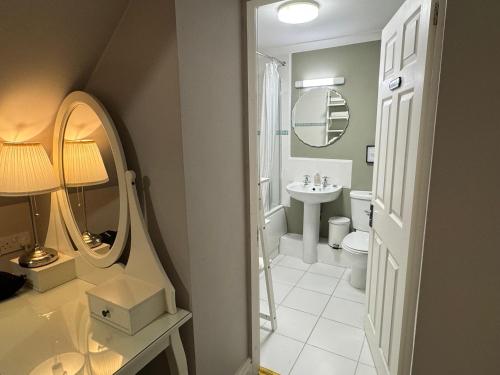 a bathroom with a sink and a toilet and a mirror at Hargate Hall Self Catering in Buxton