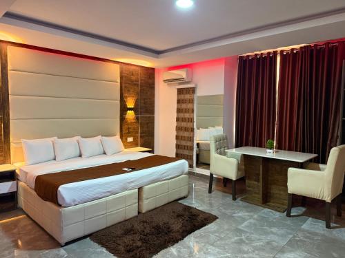 a bedroom with a bed and a table and chairs at Presken Luxury Apartments in Lagos