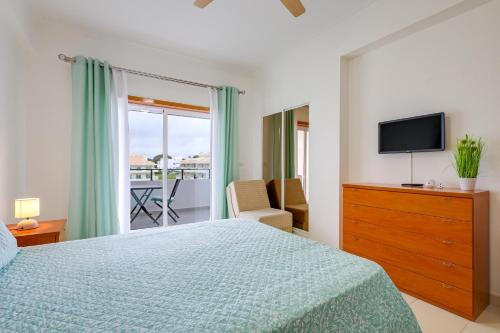 a bedroom with a bed and a television and a balcony at O Cantinho do Algarve in Porches