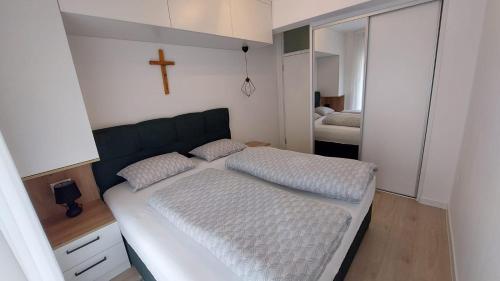 a bedroom with a large bed with a cross on the wall at Apartman Petra in Čapljina