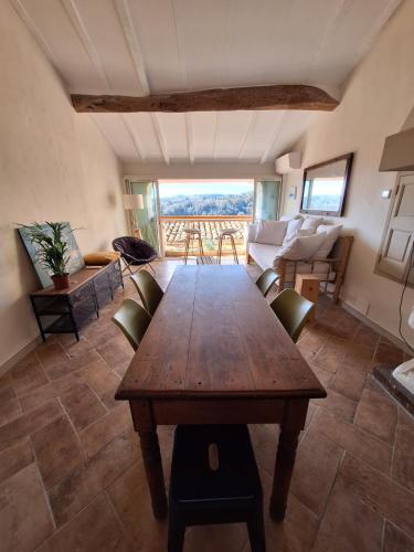 un salon avec une table et des chaises en bois dans l'établissement Vue et charme provençal à Biot - La Maison du Mitan, à Biot