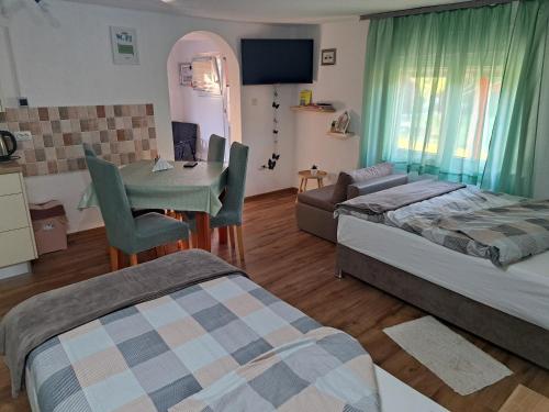 a bedroom with two beds and a table and a couch at Studio apartmani "Štimac" in Garešnica