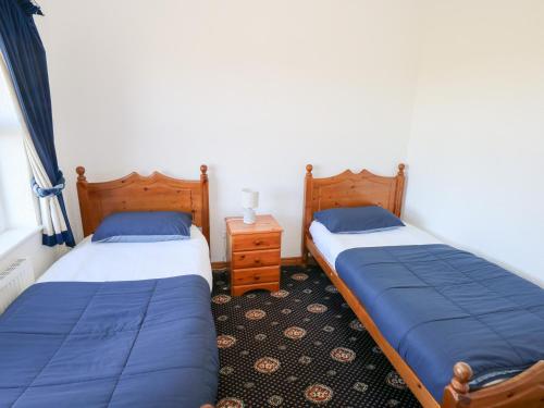 two twin beds in a room with a night stand at Realt na Maidne in Claddaghduff