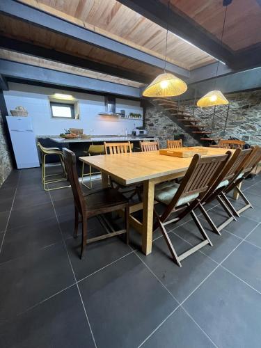 a dining room with a wooden table and chairs at Casa do Páteo in Macieira de Alcoba