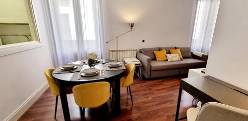 a living room with a table and chairs and a couch at La Casona del Cardenal Apto1 in Alcalá de Henares