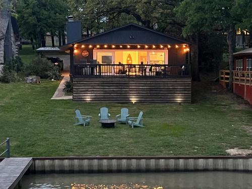 a house with a deck with chairs and lights at Harbor Point Hideaway,Sleeps 8, on open water in Gun Barrel City
