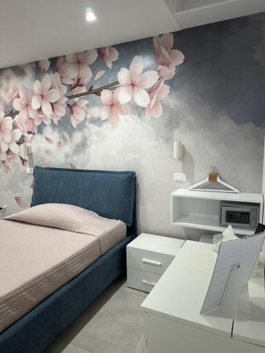 una camera da letto con un letto e fiori sul muro di B&B Chiedi la Luna a San Vito lo Capo