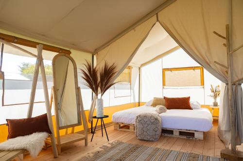 a bedroom with a bed in a tent at TinyParks Eiland Tiengemeten in Zuid-Beijerland