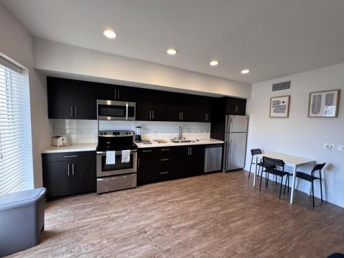 a kitchen with black cabinets and a table and a stove at Hollywood Universal Studios Apartment FREE parking in Los Angeles