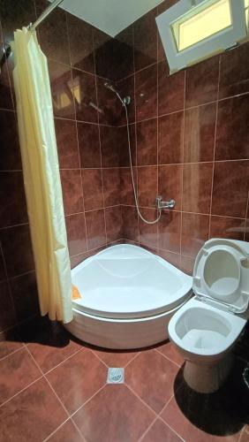 a bathroom with a tub and a toilet and a shower at Villa Ureki in Ureki