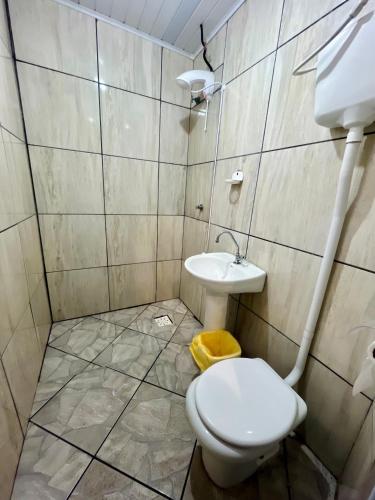 a bathroom with a toilet and a sink at Pousada DL in Pelotas