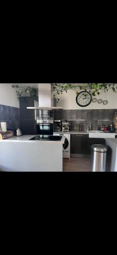 une cuisine avec une horloge murale dans l'établissement Comme chez soi 1, à Annecy