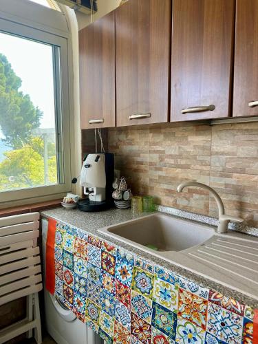 a kitchen counter with a sink and a window at Chris House Mondello in Palermo