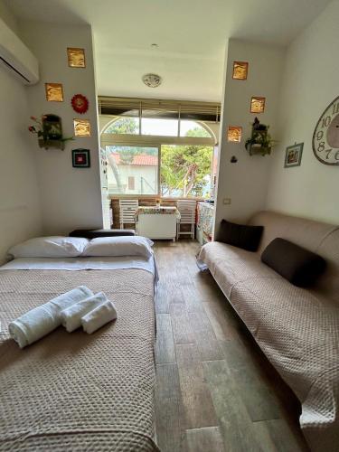 a bedroom with two beds and a living room at Chris House Mondello in Palermo