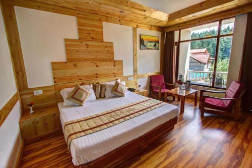 a bedroom with a bed with a wooden wall at Hotel Premium Conifer Manali Near Hadimba Devi Temple - BEST HOTEL IN MANALI in Manāli