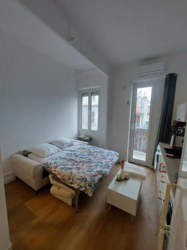 une chambre blanche avec un lit et une table dans l'établissement Apartment in Noailles Marseille, à Marseille