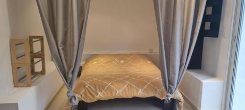 - un lit dans une chambre avec rideau dans l'établissement Location venelles, à Venelles