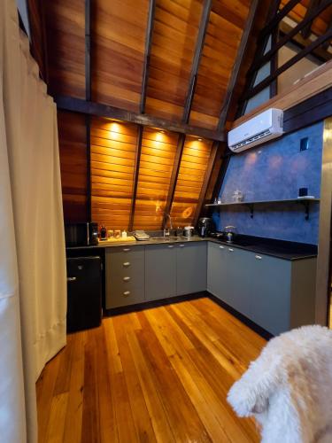a kitchen with wooden floors and a kitchen with a stove at Vila Chamonix - Chalé Malbec in Urubici