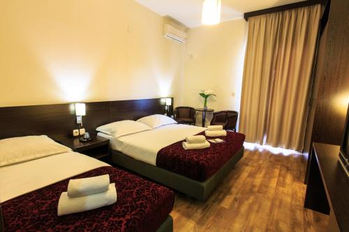 a hotel room with two beds and a television at Lucic Rooms & Suites in Budva