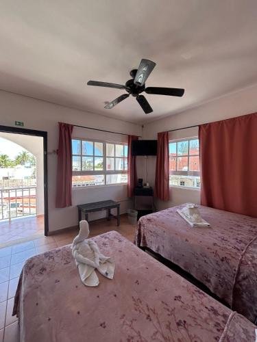 a bedroom with two beds and a ceiling fan at Hotel Marcianito in Isla Mujeres