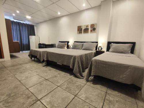 two beds in a large room with two beds sidx sidx sidx at Villa Bilac - Amplos Studios 2km da Vila Germânica in Blumenau