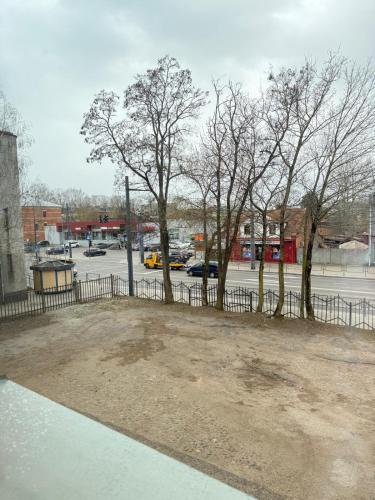 a parking lot with trees and a fence at Small but with character in Kaunas
