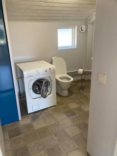 a bathroom with a washing machine and a toilet at Idyllic house in Timmernabben in Timmernabben