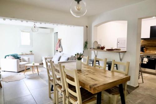 Il dispose d'une cuisine et d'un salon avec une table et des chaises en bois. dans l'établissement Ground floor , Cocoon garden , Parking , AC, à Vallauris