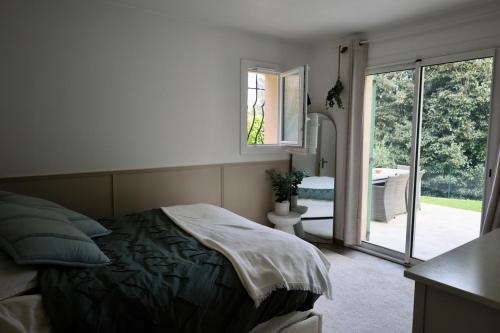 une chambre avec un lit et une porte coulissante en verre dans l'établissement Ground floor , Cocoon garden , Parking , AC, à Vallauris